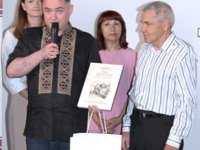 Vladyslav Hrynevych, Jr., Regional Manager of UJE's Office in Ukraine, hands an award to Petro Hrushko, the photo contest winner in the Jewish Heritage category, Kyiv, 31 May 2025.